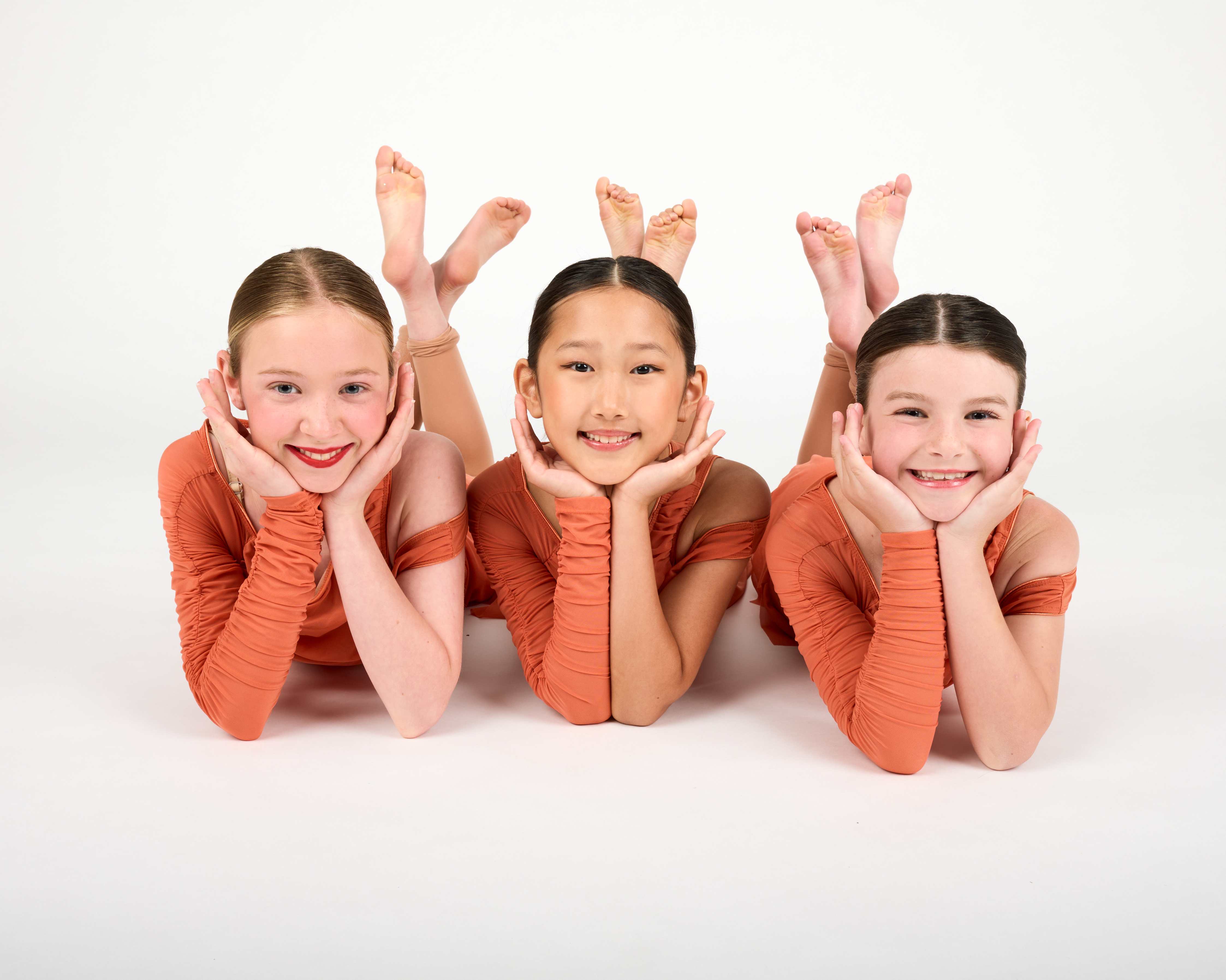 Three young Dance Connections dancers smiling together